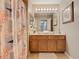 Bathroom featuring a double vanity, decorative shower curtain, and neutral tile flooring at 2632 Sand Hill Point Cir, Davenport, FL 33837