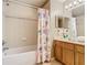Bathroom features a bathtub with shower, decorative shower curtain, single vanity, and neutral tile at 2632 Sand Hill Point Cir, Davenport, FL 33837