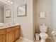 Bathroom with a single vanity, toilet, neutral walls and tile floors, plus a decorative mirror at 2632 Sand Hill Point Cir, Davenport, FL 33837