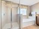 Bright bathroom featuring a glass shower and soaking tub by the window at 2632 Sand Hill Point Cir, Davenport, FL 33837