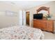 Comfortable bedroom with floral bedding, dresser with TV, and closet space at 2632 Sand Hill Point Cir, Davenport, FL 33837