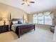 Bedroom featuring a four-poster bed, ceiling fan, large window with light and matching nightstands at 2632 Sand Hill Point Cir, Davenport, FL 33837