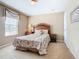 Cozy bedroom features a patterned bedspread, wooden headboard, and natural light from the window at 2632 Sand Hill Point Cir, Davenport, FL 33837