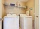 Laundry room features white washer and dryer with overhead storage shelf at 2632 Sand Hill Point Cir, Davenport, FL 33837