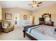 Spacious main bedroom featuring a four-poster bed, a dresser with a television and private bath access at 2632 Sand Hill Point Cir, Davenport, FL 33837