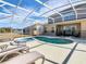Pool and spa surrounded by lounge chairs in a screened-in enclosure at 2632 Sand Hill Point Cir, Davenport, FL 33837