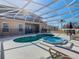 Backyard pool and spa with a screened enclosure and lounge chairs at 2632 Sand Hill Point Cir, Davenport, FL 33837