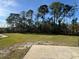 Spacious backyard with lush lawn, mature trees, and a concrete patio at 2639 Janet Ct, Deltona, FL 32738