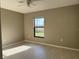 Cozy bedroom with wood-look tile floors, neutral walls, and a bright window view at 2639 Janet Ct, Deltona, FL 32738