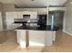 Spacious kitchen with white cabinets, black appliances, and a central island at 2639 Janet Ct, Deltona, FL 32738
