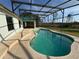 Backyard pool with screened enclosure and view of lush trees at 2639 Janet Ct, Deltona, FL 32738