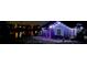 Night view of charming home illuminated by festive lighting near lake reflecting city lights at 310 Lake Ave, Dundee, FL 33838