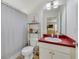 Functional bathroom featuring a vanity with a bright red countertop and shower with curtain at 3966 Avalon Park West Blvd, Orlando, FL 32828
