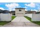Charming home exterior with a long driveway, a well-manicured lawn, and a secure white fence at 3966 Avalon Park West Blvd, Orlando, FL 32828