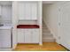 Mudroom features cabinets with a red counter and a laundry machine next to the stairs at 3966 Avalon Park West Blvd, Orlando, FL 32828