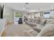 Bright open living space featuring a large gray sectional, flowing to the kitchen at 3966 Avalon Park West Blvd, Orlando, FL 32828