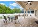 Covered outdoor patio with brick flooring, perfect for dining and relaxing with a view of the backyard at 3966 Avalon Park West Blvd, Orlando, FL 32828