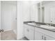 Bathroom with granite countertops, dual sinks, white cabinetry, and a walk-in shower at 4027 Copperleaf Ln, Poinciana, FL 34759