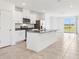 Modern kitchen showcasing white cabinetry, stainless steel appliances, a granite countertop island, and tile flooring at 4027 Copperleaf Ln, Poinciana, FL 34759