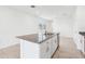 Bright kitchen island features granite counters, a stainless steel sink, and white cabinetry at 4027 Copperleaf Ln, Poinciana, FL 34759