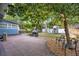 Spacious backyard featuring a brick patio, fire pit, mature trees, and outbuildings for storage or hobbies at 404 W 19Th St, Sanford, FL 32771