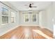 Sun-drenched bedroom featuring hardwood floors, a ceiling fan, and ample natural light from large windows at 404 W 19Th St, Sanford, FL 32771