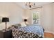 Cozy bedroom featuring a patterned bedspread, classic lighting, and a bright window, creating a relaxing atmosphere at 404 W 19Th St, Sanford, FL 32771