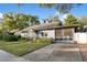 Quaint blue home boasts a neatly kept lawn, a screened porch and convenient driveway access, perfect for suburban living at 404 W 19Th St, Sanford, FL 32771