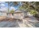 Rear exterior view showing siding, windows, and partial driveway under a beautiful tree at 424 S Observatory Dr, Orlando, FL 32835