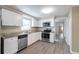 Bright kitchen with updated stainless steel appliances, granite counters and white cabinetry at 424 S Observatory Dr, Orlando, FL 32835