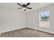 Light-filled bedroom with wood flooring, ceiling fan, and large window at 4356 Sw Dahlia Ct, Dunnellon, FL 34431