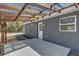 Patio boasts wooden pergola roof, concrete pad, and home entrance at 4356 Sw Dahlia Ct, Dunnellon, FL 34431