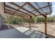 Covered patio offers a wooden pergola and concrete pad for outdoor entertainment at 4356 Sw Dahlia Ct, Dunnellon, FL 34431