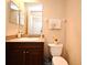 A half bathroom with a dark wood vanity, decorative sink and a toilet at 5405 Napoli Cv, Lake Mary, FL 32746
