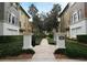 Community walkway with lush landscaping, leading to townhomes with neutral exteriors at 5405 Napoli Cv, Lake Mary, FL 32746