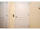 Hallway with neutral colored walls and two white panel doors at 5405 Napoli Cv, Lake Mary, FL 32746
