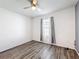Bright bedroom featuring modern ceiling fan, window with curtains, and stylish wood-look flooring at 651 Tortugas St, Haines City, FL 33844
