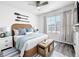 Bright bedroom featuring a rattan bedframe, modern accents, and wood floors at 651 Tortugas St, Haines City, FL 33844