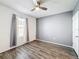 Cozy bedroom with wood flooring, gray accent wall, and neutral window treatments at 651 Tortugas St, Haines City, FL 33844