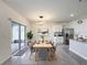 Open-concept dining area with neutral tones, a wooden table set for six, and access to the outdoor patio at 651 Tortugas St, Haines City, FL 33844