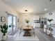 Bright dining space with a wooden table, access to the patio, and a kitchen featuring stainless steel appliances at 651 Tortugas St, Haines City, FL 33844