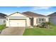 Charming single-story home boasting a well-manicured lawn, attached garage, and inviting curb appeal at 651 Tortugas St, Haines City, FL 33844