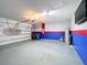 Spacious garage with vibrant blue and red accents and ample space for parking and storage at 651 Tortugas St, Haines City, FL 33844