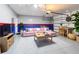 Converted garage features a pink sofa, table, and TV, offering a cozy and functional entertainment area at 651 Tortugas St, Haines City, FL 33844
