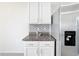Bright kitchen features granite countertops, white cabinetry, and stainless steel refrigerator at 651 Tortugas St, Haines City, FL 33844