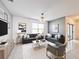 Spacious living room featuring dark sofas, modern art, a glass coffee table, and neutral accents, creating a chic gathering space at 651 Tortugas St, Haines City, FL 33844