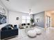 Bright living room featuring a mix of blue and grey furniture, art, and decor, offering a comfortable and stylish living space at 651 Tortugas St, Haines City, FL 33844
