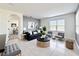 Well-lit living room featuring neutral tile floors, modern decor, and a glimpse into the dining area at 651 Tortugas St, Haines City, FL 33844
