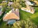 Aerial view of a large home featuring a screened pool area, clay tile roof, and spacious green yard at 6533 Cartmel Ln, Windermere, FL 34786