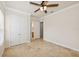 Neutral bedroom with a ceiling fan, tile floors, and closet with double doors at 6533 Cartmel Ln, Windermere, FL 34786